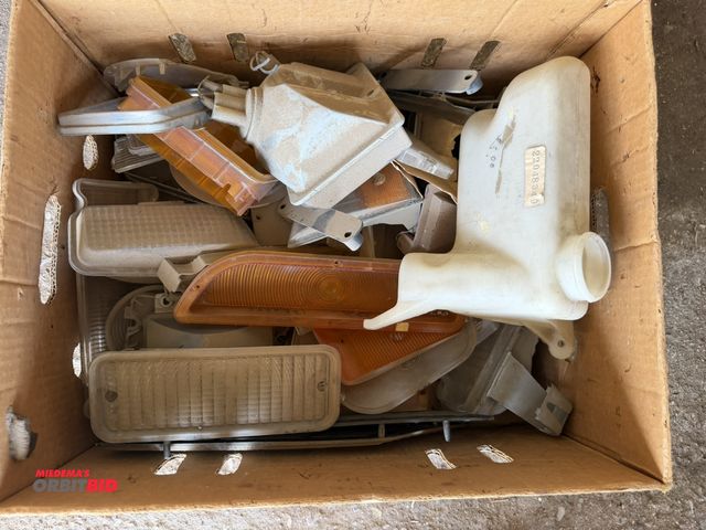 Lot 1-8554 - Lot of vintage GM stock headlights, reservoir trim pieces, and more, new/old stock.