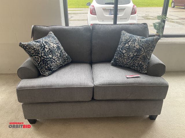 Lot 1-17153 - Grey love seat with (2) pillows. 66” long by 41” deep