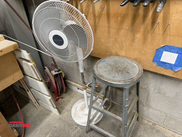 Lot 1-16640 - (1) Holmes pedestal fan, (1) shop stool, and (1) retractable air hose reel mounted to floor, winning...