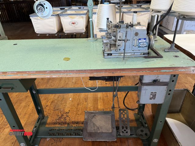 Lot 1-4694 - (1) The Merrow commercial sewing machine, model M-4DW-60, S/N 145382, mounted on Singer power table,...