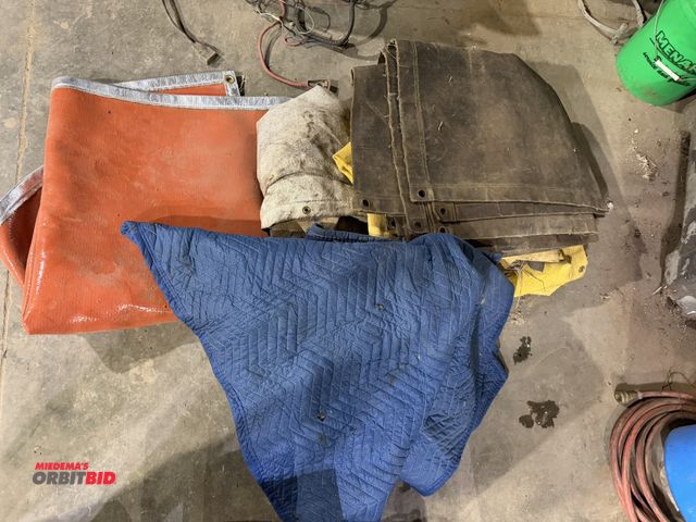 Lot 1-1546 - Lot of approx. (5) assorted canvas tarps, (1) vinyl/rubber warming blanket, and (1) moving blanket.