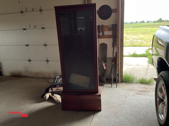 Lot 1-17863 - 24.5” width x 70” height x 12” depth single door wood gun cabinet with glass insert in door and lowe...