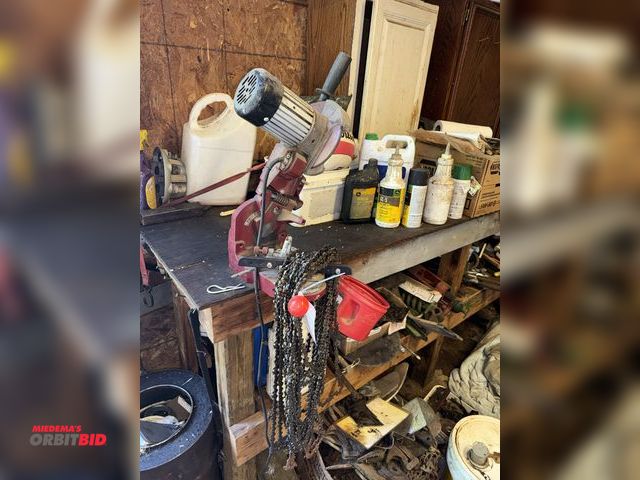 Lot 1-19932 - (1) bench mount chainsaw blade sharpener, 120V, and assorted chainsaw blades, winning bidder respons...