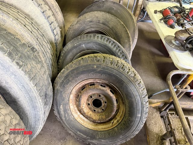 Lot 1-18185 - Lot including (1) size 8.25R 15TR tire with ring, (1) size 235/85R16 tire with 8-lug rim, (1) size 9...