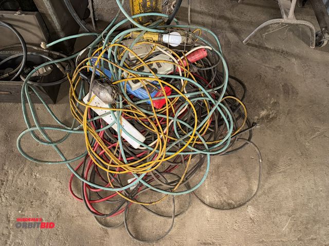 Lot 1-18120 - Large lot of assorted extension cords, work lights, and surge strips.