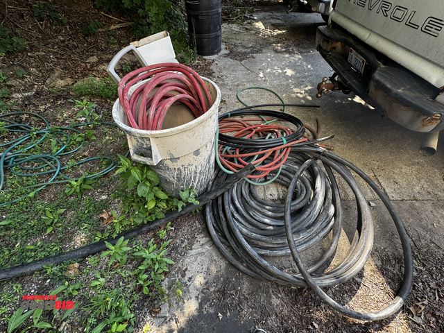 Lot 1-14259 - Large lot of assorted garden hoses, Speedaire 1", 200 PSI hose, (1) Suncast hose reel, and more.