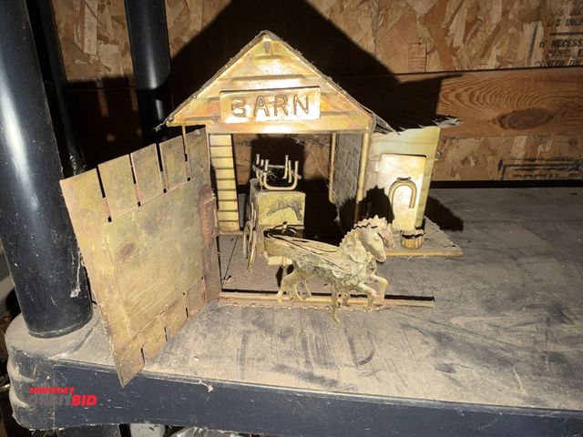 Lot 1-8337 - (1) vintage collectible tin barn shaped music box with rotating horse and carriage.