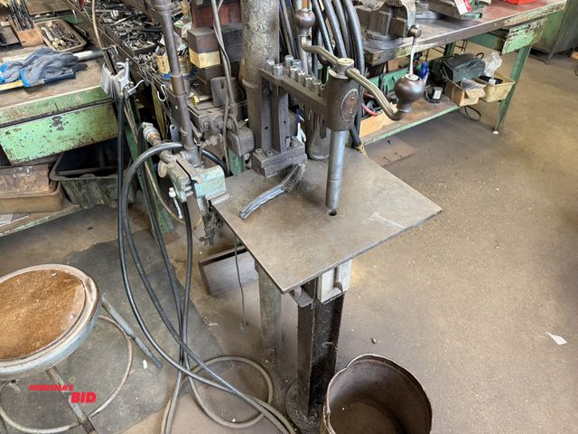 Lot 1-18545 - (1) make and model unknown, post mounted, manual operated capping tool with a 16" x 15" steel table,...