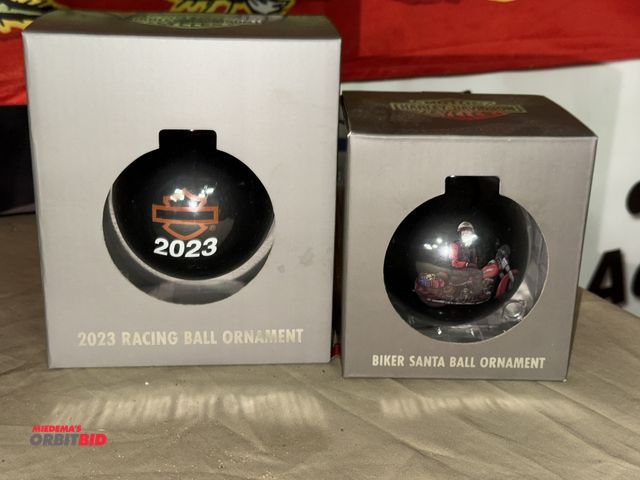 Lot 1-8274 - (1) 2023 collectible Racing bulb ornament, and (1) 2024 Biker Santa ornament.