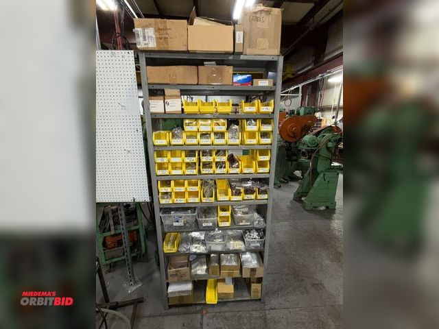 Lot 1-18948 - Rack with contents, includes assorted Howard Miller clock hands, and pendulum parts.