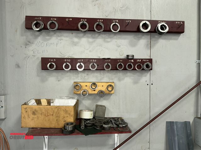 Lot 1-19212 - Entire contents of various sized spacers and shims shown on wall and shelving.