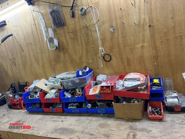 Lot 1-18527 - Entire contents of bins on bench, includes various batteries, trimmer line, razor blades with dispen...