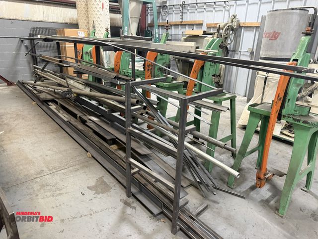 Lot 1-18542 - (1) rack of assorted metals, includes 3" x 3" x 20' right angle, 6" and 4.5" wide flat stock, 2" rou...