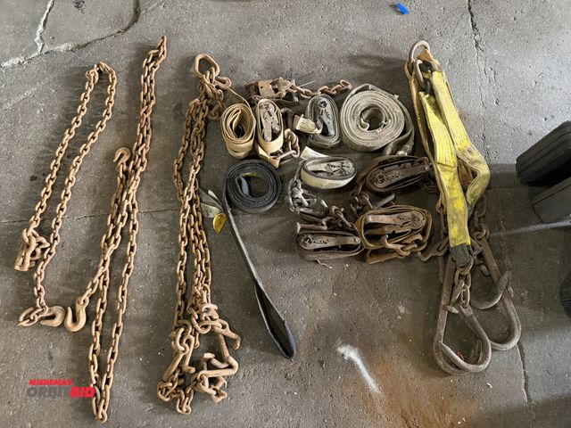 Lot 1-1277 - Lot of assorted ratchet down straps for flatbed truck, includes chains, tow hooks, and tow straps.