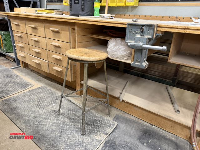 Lot 1-16582 - (1) custom built 12-drawer wood table, 10' length x 29" depth x 36" height, with Wilton 7" clamp.