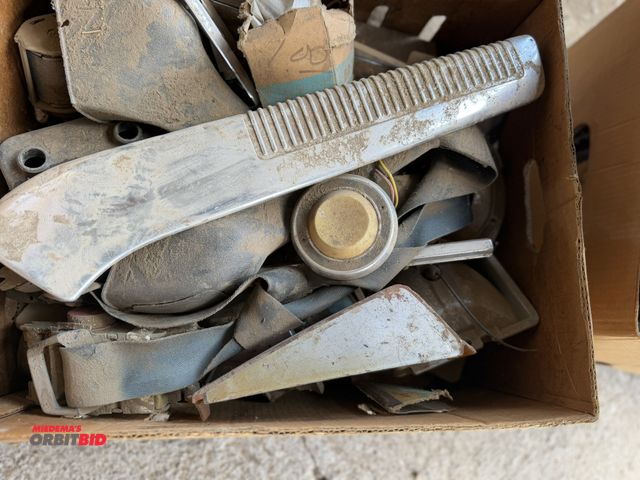 Lot 1-8555 - Large lot of assorted vintage GM parts, includes seat belts, lens covers, trim pieces, and more.