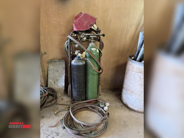 Lot 1-14201 - (1) torch cart with hoses, assorted guns, (1) 28" tall compressed oxygen tank, (1) 21" tall acetylen...