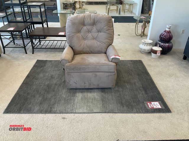 Lot 1-17182 - Light brown reclining/rocking chair with rug. Rug measures 87” by 60”