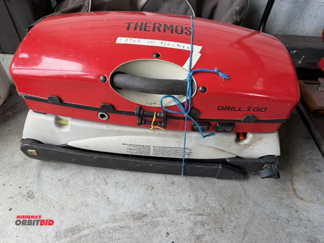 Lot 1-12157 - (1) Thermos Grill 2 Go portable propane camping grill with accessories, and cover, latch is broken.