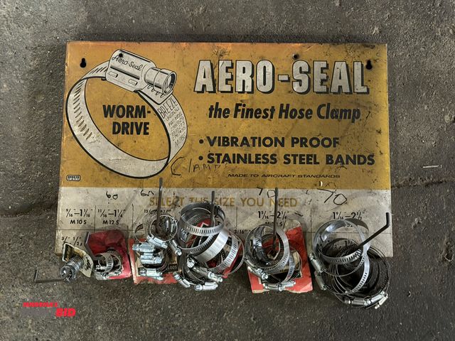 Lot 1-1182 - (1) vintage Aero-Seal 18" wide x 12" tall metal hose clamp display with assorted hose clamps.