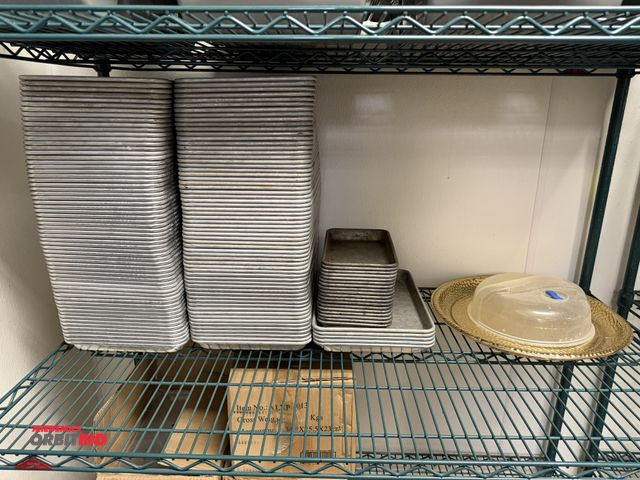 Lot 1-11136 - Entire content of shelf shown in photo, includes approx. (130) Winco 12" x 9" aluminum sheet pans, a...