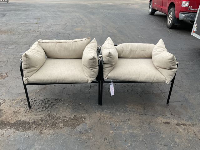 Lot 106-001208 - Set of 2 matching black metal and tan cushion chairs.