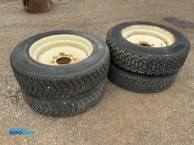 Lot 2-40387 - (4) Used Recap 255/70R22.5 Tires on Steel 8-lug Wheels for Skid Steer, 8 on 8" bolt pattern, were us...
