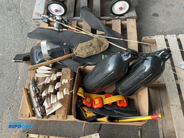Lot 2-75056 - Skid lot of fishing poles, foldable shovel, model sail boat, wet suit, and more