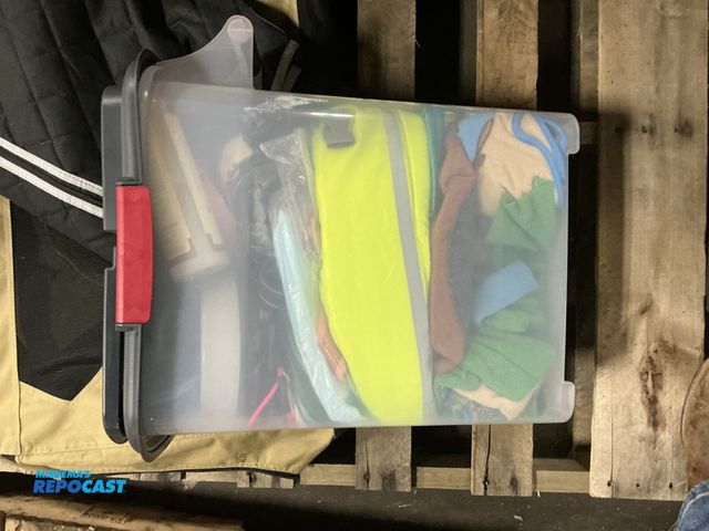 Lot 2-27161 - Skid lot of a bin of clothes, a dog travel bag, a pet seat cover, and a storage bag