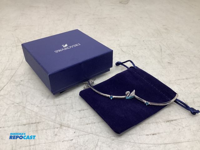 Lot 2-74026 - New Swarovski iconic crystal swan bangle/bracelet, rhodium plated band with blue crystals and a cent...