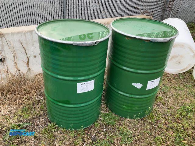 Lot 2-94816 - lot of 2 55 gallon green steel barrels with removable lids and locking rings, contained apple juice