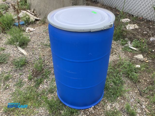 Lot 2-18411 - 55 gallon blue plastic barrel with removable lid and locking rings. Clean inside. Contained food pro...