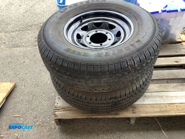 Lot 2-64410 - 2 trailers tires/wheels, 6 bolt ST225/75R15, one has a slow leak