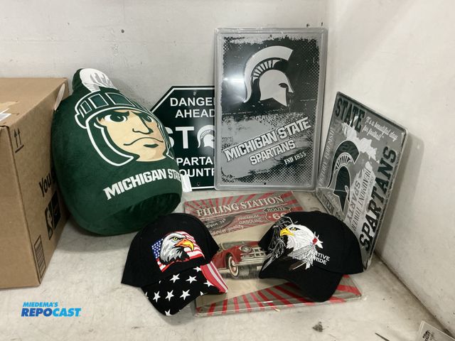 Lot 2-73412 - Lot of various MSU memorabilia including aluminum signs, plush pillow and USA caps and sign.