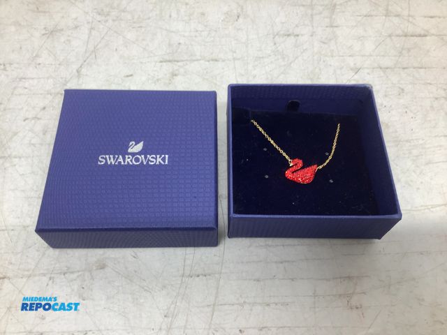 Lot 2-75673 - New Swarovski iconic red gemmed, gold-toned plated chain swan pendant necklace
