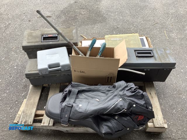 Lot 2-27208 - Skid lot of misc items including: motorcycle seat, leather jacket, nailer gun, plumbing pipe fitting...