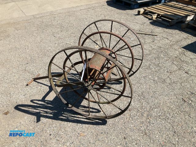 Lot 2-35686 - antique fire department hose cart, featuring large metal wheels and a reel for storage.