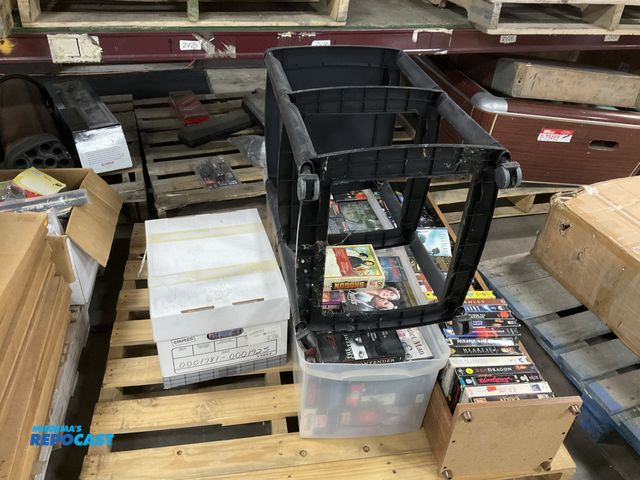 Lot 2-64093 - Skid lot of various VHS Tapes, a plastic Storage Frame on wheels, and a Wooden Bookshelf measuring 1...