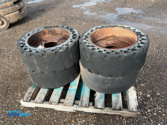 Lot 2-40338 - (4) Used 31x6x10 Solid Rubber Skid Steer Tires/Wheels, 8 on 8” bolt pattern, one wheel center is cra...