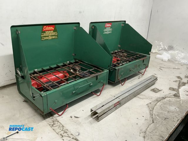 Lot 2-36943 - two coleman gas camp stoves. model 425-D. dual burners, easy carry handles and attached legs for tab...