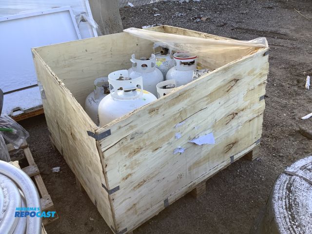 Lot 2-73162 - Wooden box skid of (8) assorted sized propane tanks