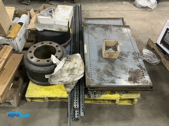 Lot 2-14773 - Skid lot of assorted trucks parts, shelving, etc. includes two semi brake drums, metal racks, chains...