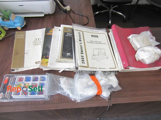Lot 31-1300 - Golf Cart Ownerâ€™s Manuals, Crankshaft Bearing, Camera, Assorted Electrical Terminals
