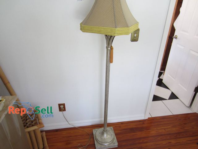 Lot 31-9112 - Floor Lamp Featuring A Beige Fabric Shade And A Metal Base With Decorative Details.