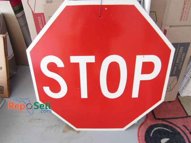 Lot 31-9147 - Red metal stop sign with white lettering, octagonal in shape. The sign measures approximately 30 inc...