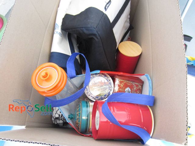 Lot 31-9207 - Large box containing various items, including reusable bags, a thermos with an orange lid, lidded co...