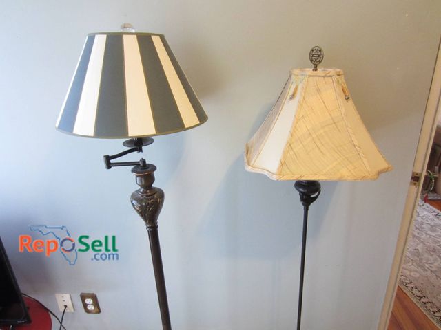 Lot 31-9010 - Two Floor Lamps Featuring Metal Bases, One With A Striped Shade And One With A Beige Shade.
