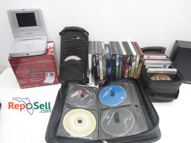 Lot 31-3445 - Electronics Lot: (6) DVD/CD Cases, Portable DVD Player (Power On), DVD's, (1) Hard Shell Carry Case:...
