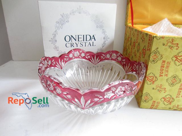 Lot 31-9303 - Oneida crystal bowl featuring a floral-cut pattern and a red overlay design on the rim. Includes the...