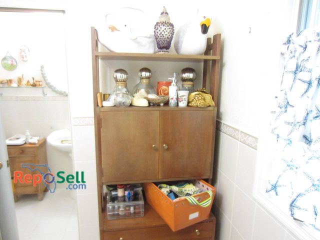 Lot 31-9323 - Contents of Bathroom Cabinet: including decorative glass bottles, nail polish in a clear plastic org...